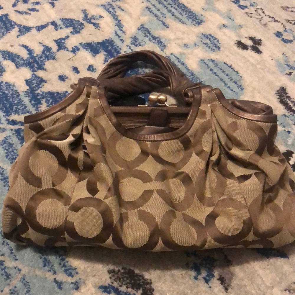 Brown and tan Coach bag with gold accents. Some minimal staining. Great bag.